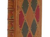 un vieux livre dont la couverture est ornée d'un motif en losanges