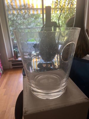 a glass vase sitting on top of a box in front of a window