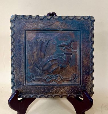 a picture of a metal plaque with a bird on it