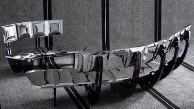 une sculpture métallique représentant un bateau, posée sur une table