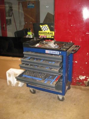 un chariot à outils bleu contenant des outils, dans un garage