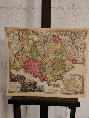 une vieille carte de l'Europe posée sur un support devant un mur de briques blanches