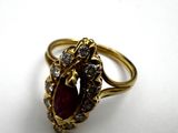 an image of a close up of a gold ring with a red stone