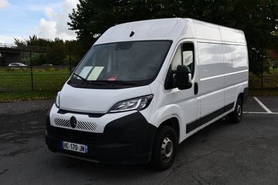 la camionnette blanche est garée sur le parking à côté des arbres