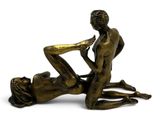 bronze statue of a man and a woman laying on the ground