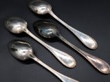 three silver spoons and two silver spoons on a black surface