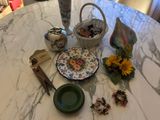 a table with a vase, a plate, and other items on it