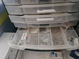a stack of plastic drawers that have various items in them