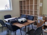 une pièce avec une table, des chaises et une imprimante dessus