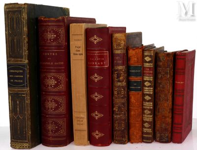 several old books are lined up in a row on a white surface