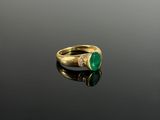 a close up of a gold ring with a green stone