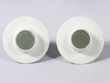pair of white porcelain vases with green glazes on them