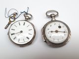 deux montres de poche en argent posées l'une à côté de l'autre sur une table