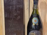 a bottle of wine sitting next to a box on a shelf