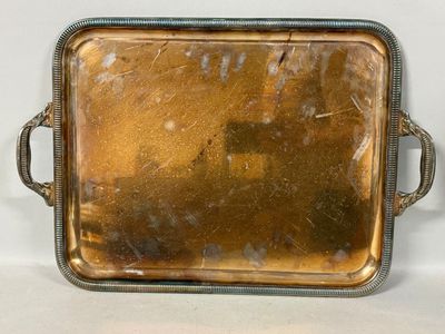 un plateau en métal muni d'une poignée, posé sur une table
