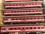 several red train cars are stacked on top of each other in a cardboard box