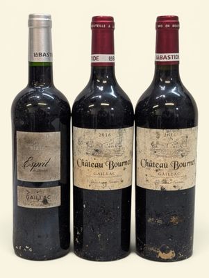 trois bouteilles de vin rouge sont posées les unes à côté des autres sur une surface blanche