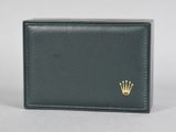 a black leather wallet with a gold crown on the front