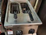 two deep fryers in the middle of a kitchen