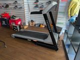 a treadmill in a store with a man standing next to it