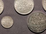four different types of silver coins are shown on a table