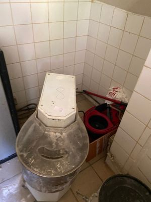 a toilet in the corner of a bathroom with a trash can
