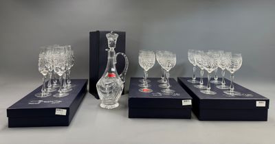 four wine glasses and a decanter in a box on a table