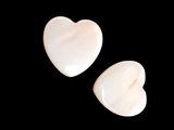 two white heart shaped stones on a black background