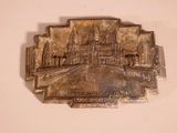 une plaque métallique sur laquelle figure l'image d'un bâtiment