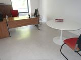 une table et des chaises dans une pièce équipée d'un bureau et d'une télévision