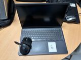 un ordinateur portable posé sur une table, avec une souris à côté