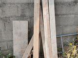 a pile of wood sitting on the ground next to a wall