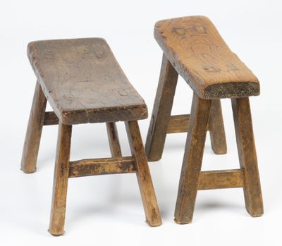 deux tabourets en bois placés l'un à côté de l'autre sur une surface blanche