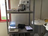 a small kitchen with a metal shelf and a tv