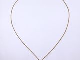a gold necklace with an orange stone on a gold chain