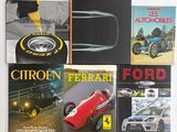 plusieurs livres posés sur une surface blanche, avec une voiture rouge au milieu