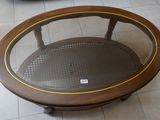 une table ronde avec un plateau en verre, posée sur un sol carrelé