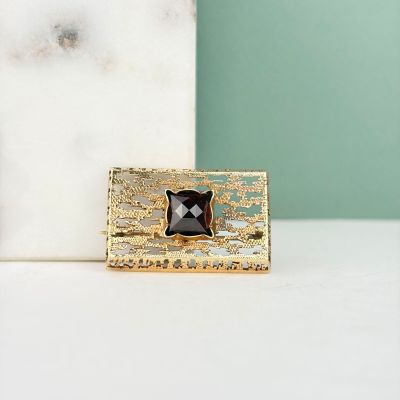 un chat noir et blanc assis sur une assiette dorée