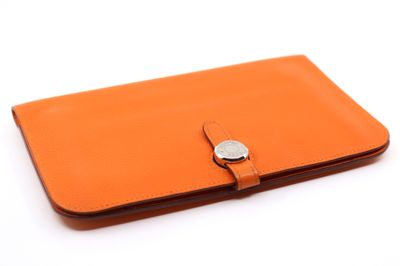 un portefeuille en cuir orange muni d'un fermoir métallique