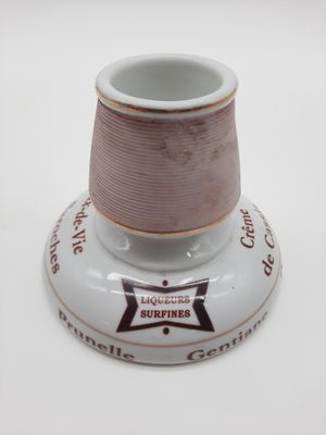 une petite tasse posée sur une soucoupe, sur une table blanche