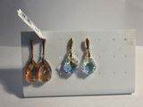 trois paires de boucles d'oreilles exposées sur un fond blanc