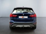 the rear end of a blue bmw suv parked in a room