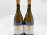 deux bouteilles de vin posées l'une à côté de l'autre sur une surface blanche