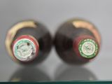 two bottles of wine sitting on a glass shelf