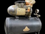 a toy man sitting on top of an old air compressor