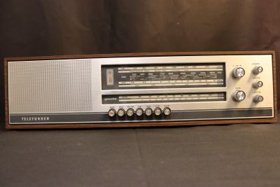 an old radio sitting on top of a table next to a brown wall