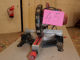 a pink sign on a miter saw in a room