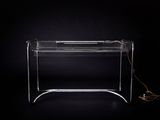 bureau en plexiglas transparent sur lequel sont posés un clavier et une souris
