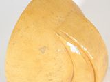 a yellow sculpture of a heart shaped object on a white surface