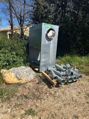 une poubelle et un tas de tuyaux par terre